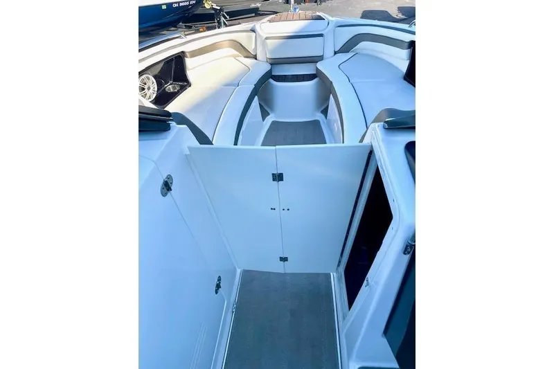 Slide: The Image of 2015 Yamaha Boats 242 Limited S interior with open storage compartment and seating area. - 15