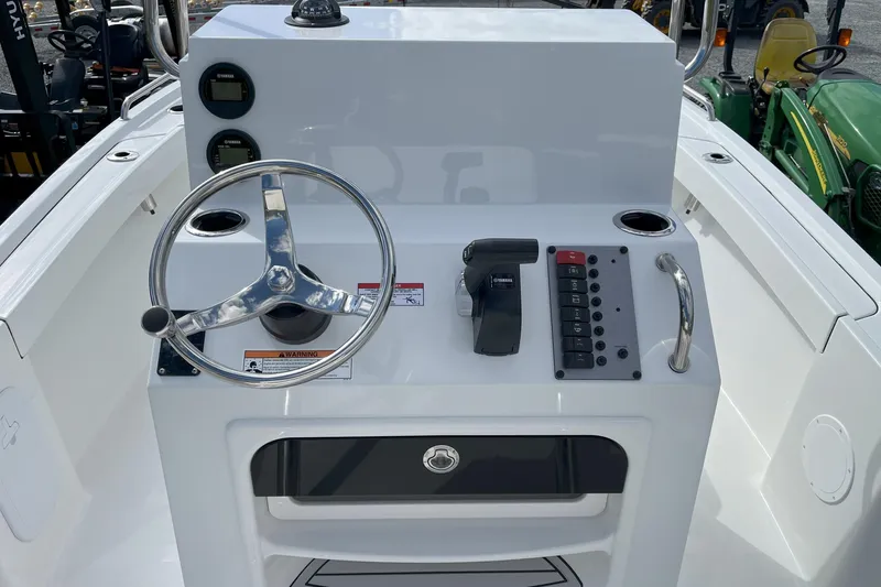 Slide: The Image of Control console of a 2026 Parker 180 Coastal boat with steering wheel and controls. - 2