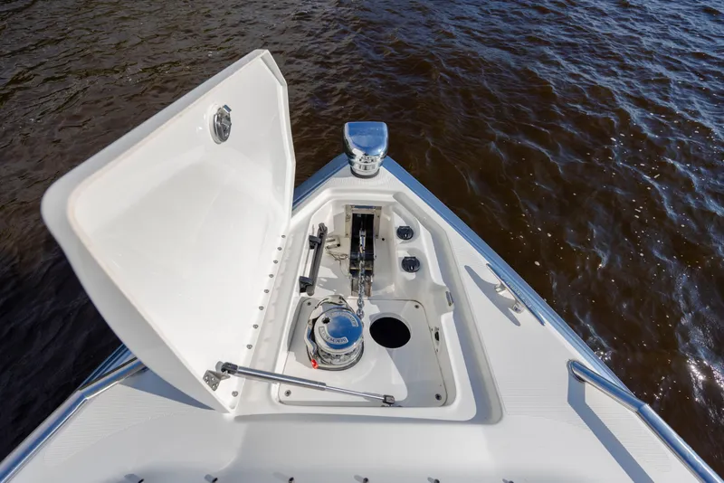 Slide: The Image of 2018 Formula 350 Crossover Bowrider OB anchor compartment open on calm water. - 26