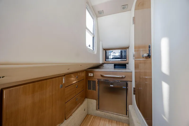 Slide: The Image of 2018 Formula 350 Crossover Bowrider OB interior with wood cabinetry and stainless steel appliances. - 35