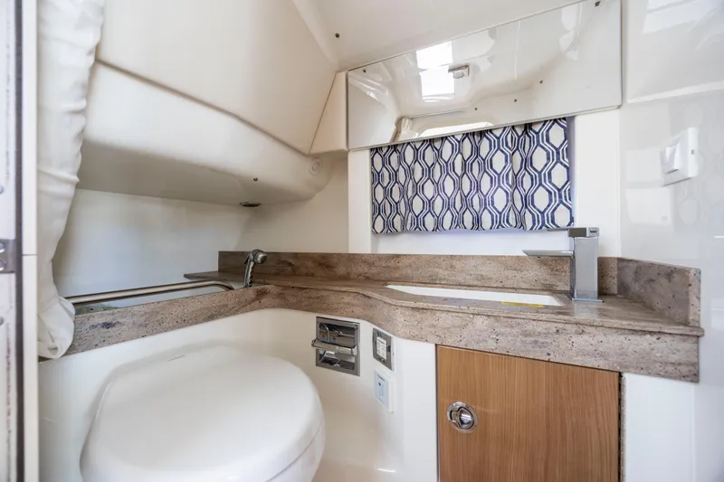 Slide: The Image of 2018 Formula 350 Crossover Bowrider OB bathroom with modern sink and patterned curtain. - 36