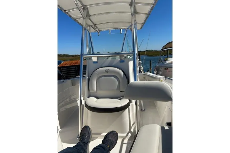Slide: The Image of 2023 Sailfish 220CC boat interior with seating and canopy on a sunny day. - 4