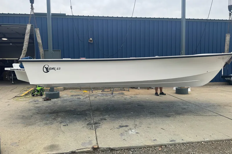 Slide: The Image of 2026 C-Hawk 23 Center Console boat suspended at a marina. - 2