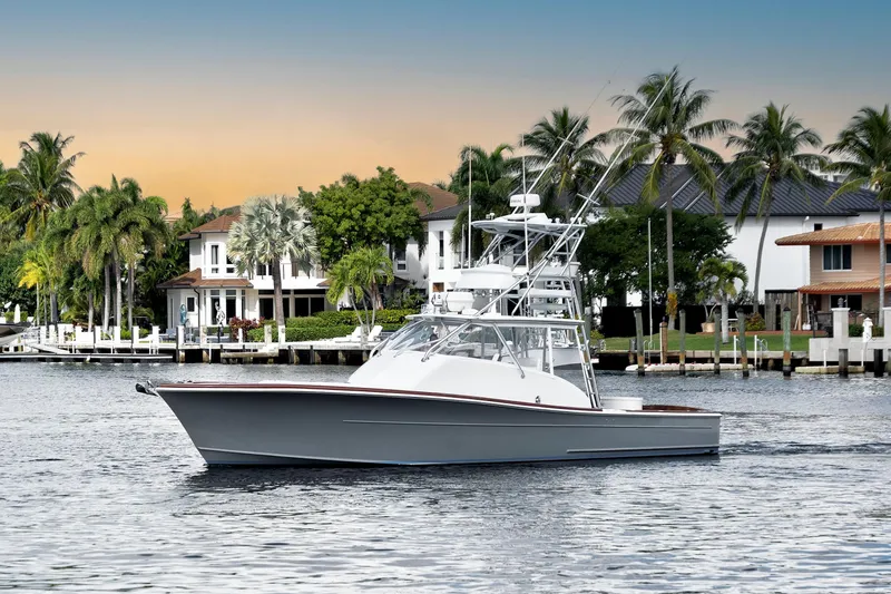 Slide: The Image of 2014 Release Walkaround boat cruising near waterfront homes at sunset. - 1