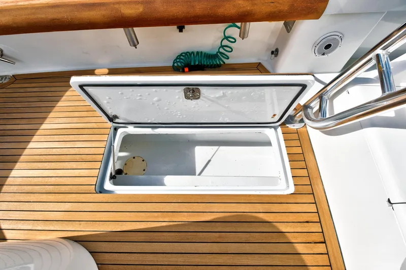 Slide: The Image of Open storage compartment on 2014 Release Walkaround boat with teak flooring. - 11