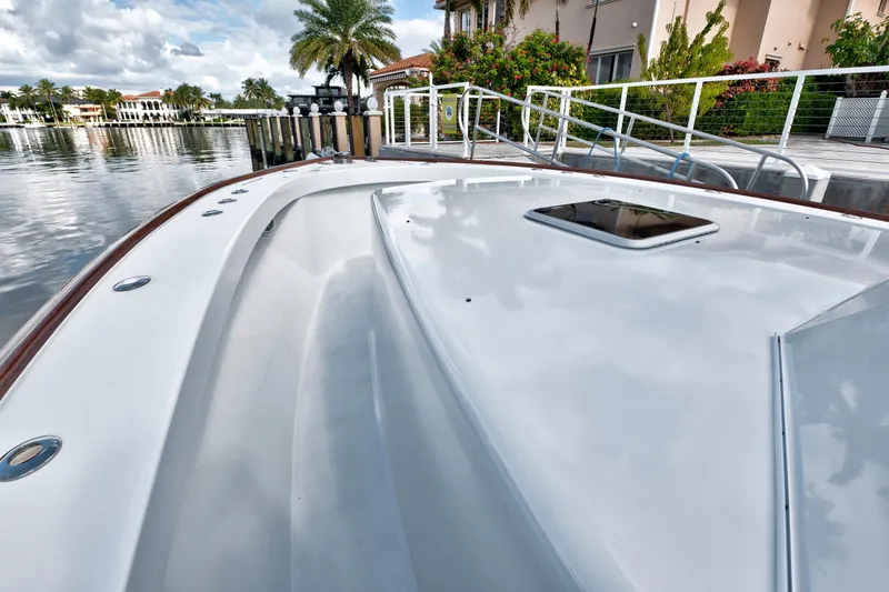 Slide: The Image of 2014 Release Walkaround boat docked by waterfront with palm trees and cloudy sky. - 19
