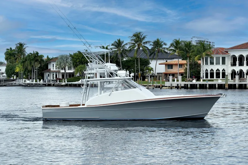 Slide: The Image of 2014 Release Walkaround boat cruising near waterfront homes with palm trees. - 2