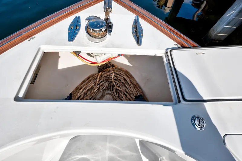 Slide: The Image of Open storage compartment on 2014 Release Walkaround boat with coiled rope and winch. - 20