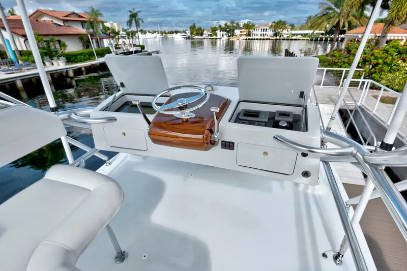 Slide: The Image of Boat helm station with wooden steering wheel, overlooking a scenic waterfront view. - 23