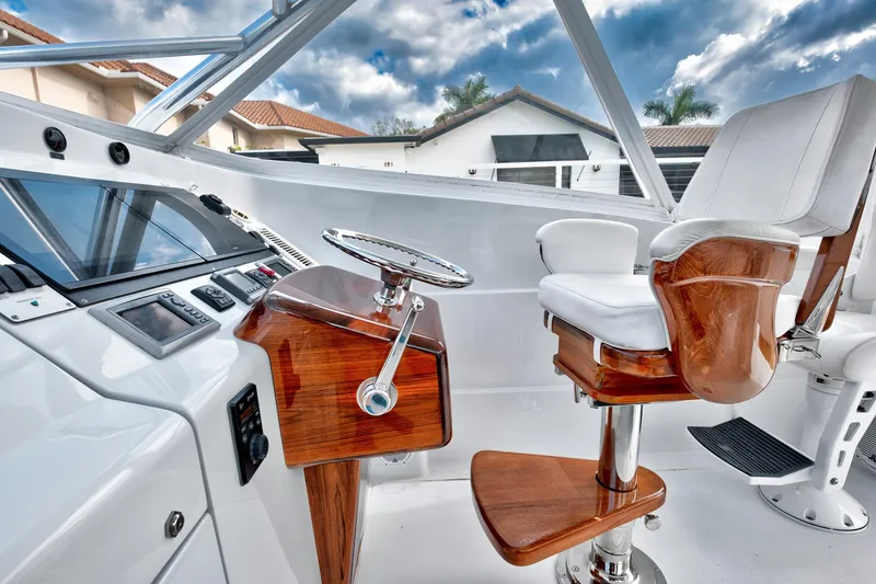 Slide: The Image of Luxurious 2014 Release Walkaround boat helm with polished wood and white seating. - 27