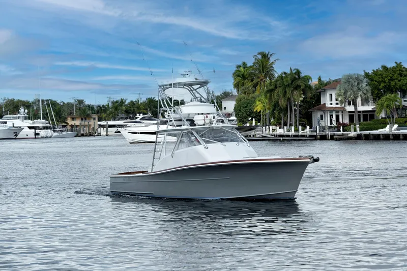 Slide: The Image of 2014 Release Walkaround boat cruising in a scenic marina with palm trees and yachts. - 4