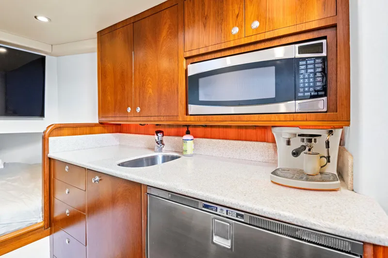 Slide: The Image of 2014 Release Walkaround yacht kitchen with microwave, espresso machine, and wooden cabinetry. - 41