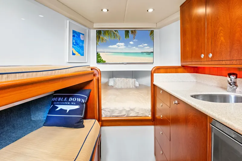 Slide: The Image of Luxurious yacht interior with wood cabinetry, cozy bed, and scenic beach view. - 45