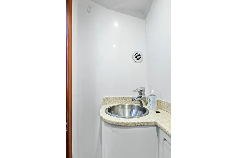 Slide: The Image of Compact boat bathroom with stainless steel sink, granite countertop, and soap dispenser, 2014 Release Walkaround. - 51
