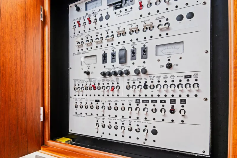 Slide: The Image of Electrical control panel inside a wooden cabinet on a 2014 Release Walkaround boat. - 54