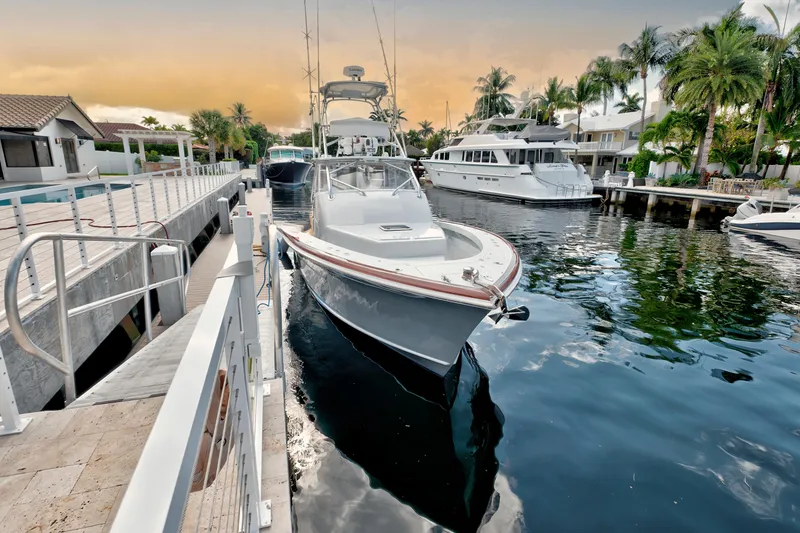 Slide: The Image of 2014 Release Walkaround boat docked in a scenic marina with palm trees and yachts. - 6