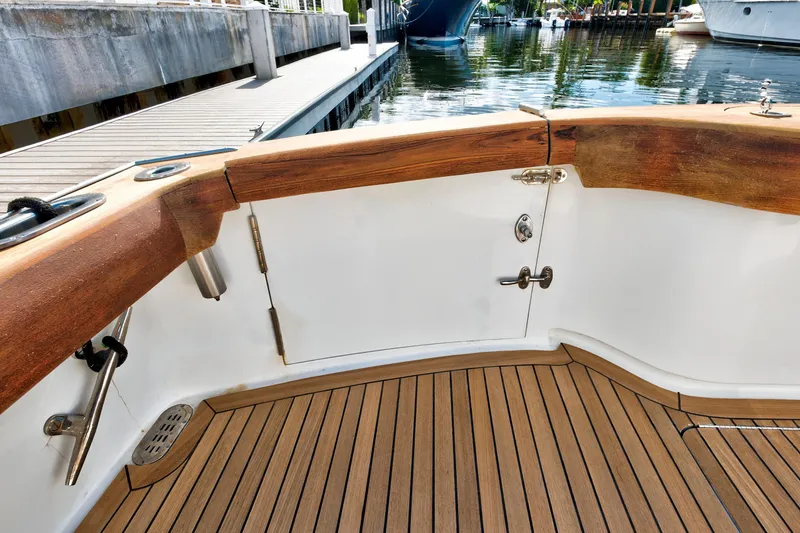 Slide: The Image of 2014 Release Walkaround boat deck with wooden finish and dock view. - 8