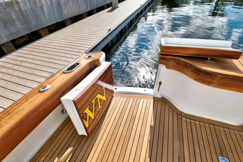 Slide: The Image of Wooden deck of 2014 Release Walkaround boat docked by the water. - 9