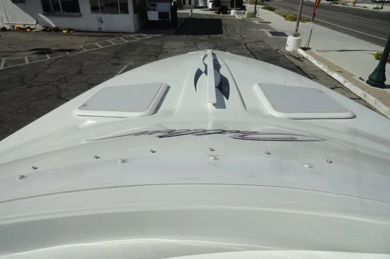 Slide: The Image of 1998 Baja 29 Outlaw boat, top view, parked on asphalt near a building. - 16
