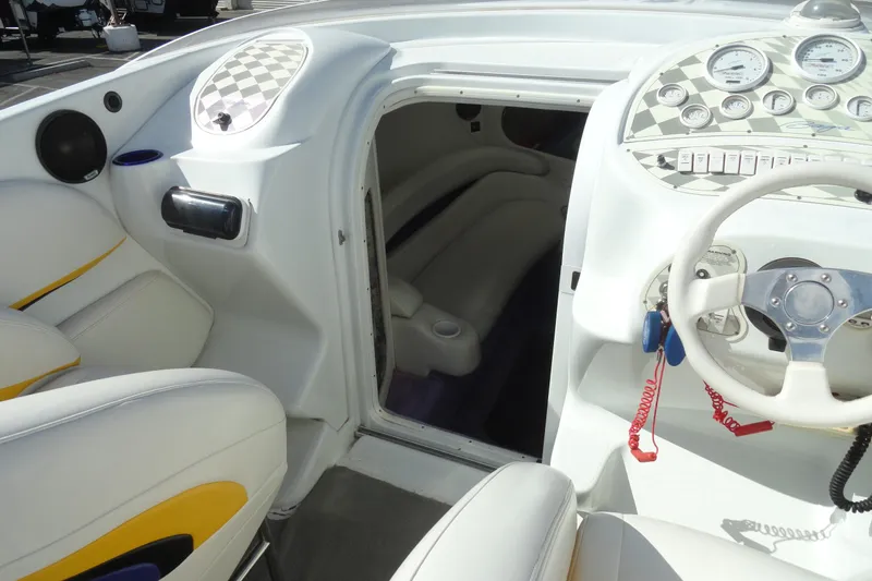 Slide: The Image of 1998 Baja 29 Outlaw boat interior with white seating and dashboard controls. - 17