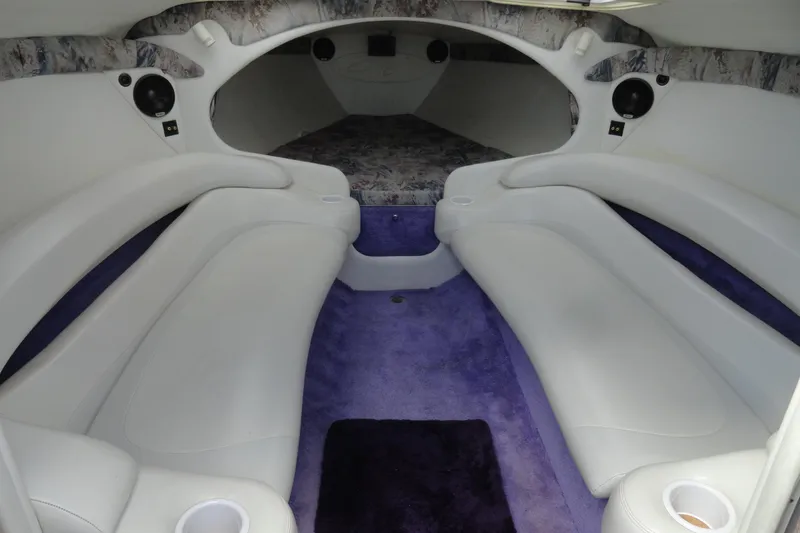 Slide: The Image of Interior of a 1998 Baja 29 Outlaw boat with white seating and purple carpet. - 18