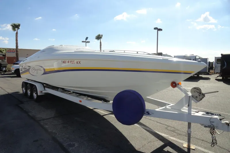 Slide: The Image of 1998 Baja 29 Outlaw speedboat on trailer in sunny parking lot. - 4