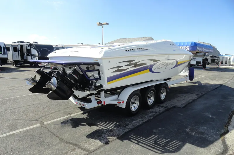 Slide: The Image of 1998 Baja 29 Outlaw boat on trailer in parking lot, showcasing sleek design and vibrant graphics. - 6