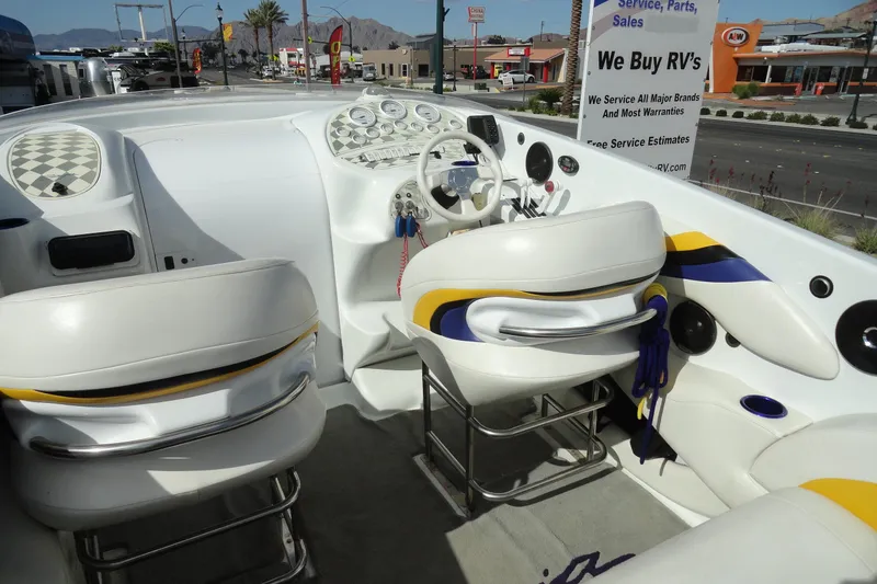 Slide: The Image of 1998 Baja 29 Outlaw boat interior with white and yellow seating, dashboard, and controls. - 8