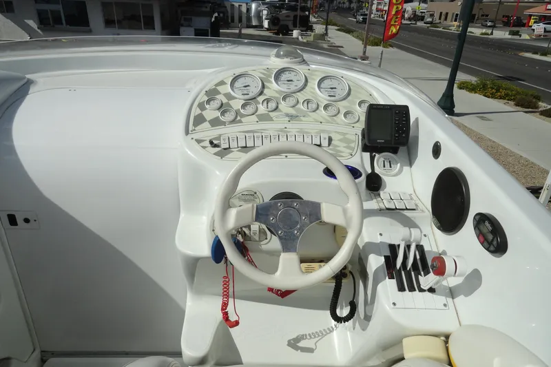 Slide: The Image of 1998 Baja 29 Outlaw boat dashboard with steering wheel, gauges, and controls. - 9