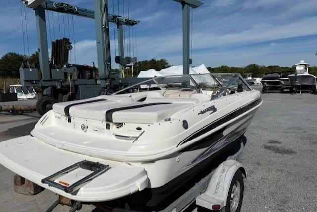 Slide: The Image of 2009 Glastron GT 185 boat on trailer in marina setting under clear sky. - 3