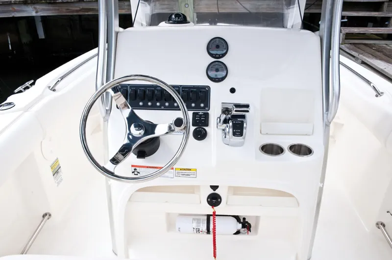 Slide: The Image of 2014 Boston Whaler 220 Outrage boat console with steering wheel and controls. - 10