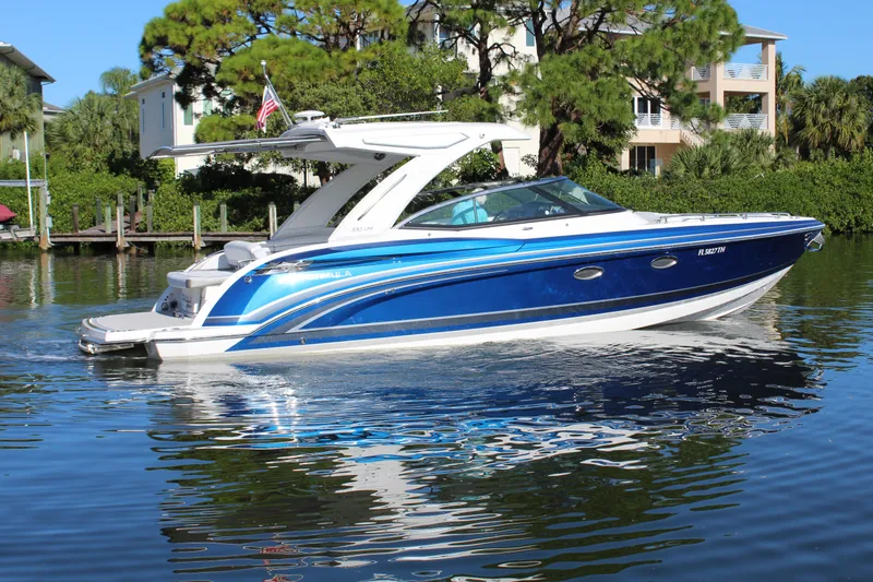 Slide: The Image of 2023 Formula 330 Crossover Bowrider in vibrant blue on a serene waterway. - 11