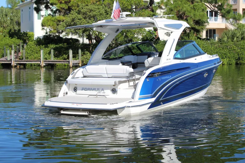 Slide: The Image of 2023 Formula 330 Crossover Bowrider on calm water, showcasing sleek design and luxury features. - 12