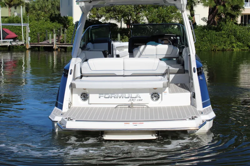 Slide: The Image of 2023 Formula 330 Crossover Bowrider on water, rear view, showcasing spacious seating. - 13