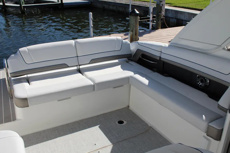 Slide: The Image of 2023 Formula 330 Crossover Bowrider interior seating area by the water. - 27