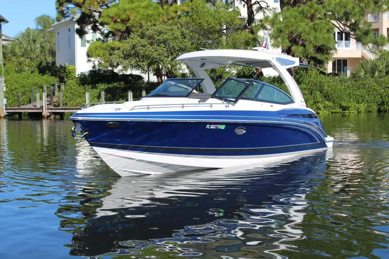 Slide: The Image of 2023 Formula 330 Crossover Bowrider on calm water, surrounded by lush greenery. - 3