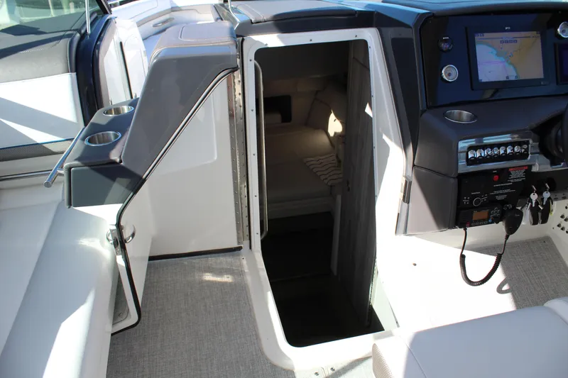 Slide: The Image of 2023 Formula 330 Crossover Bowrider cabin entrance with cockpit controls and seating. - 34