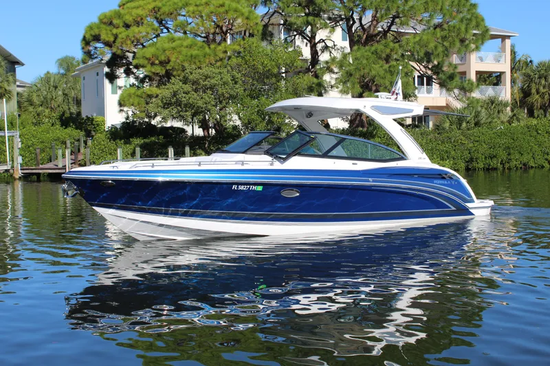 Slide: The Image of 2023 Formula 330 Crossover Bowrider on calm water, surrounded by lush greenery. - 4