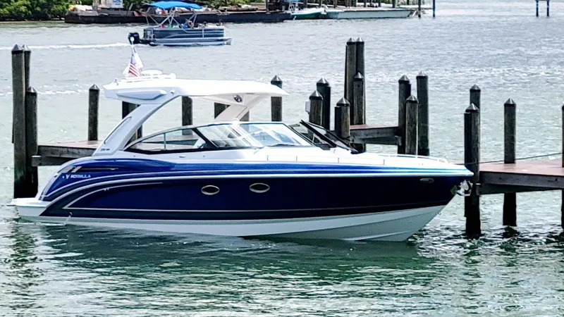 Slide: The Image of 2023 Formula 330 Crossover Bowrider docked in a scenic marina setting. - 44