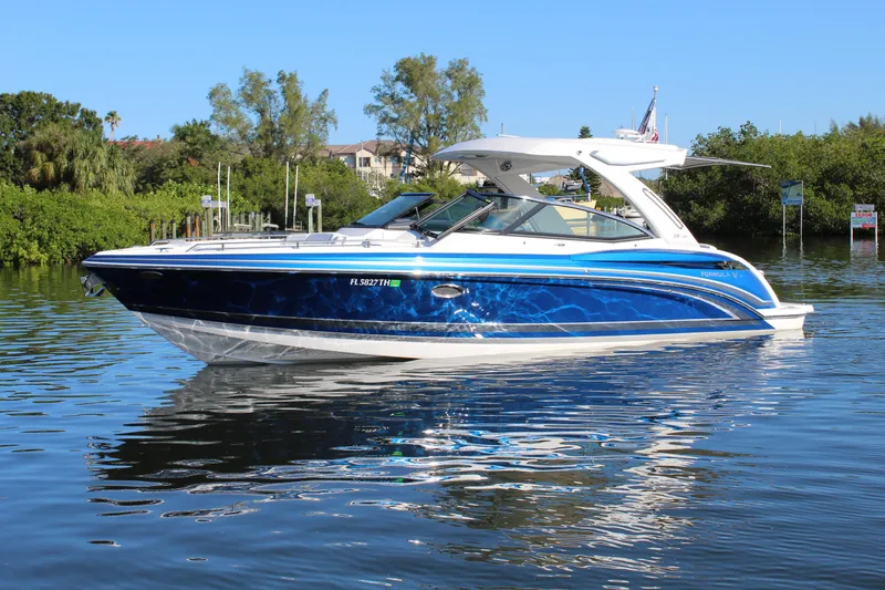 Slide: The Image of 2023 Formula 330 Crossover Bowrider on calm water, showcasing sleek design and vibrant blue color. - 5