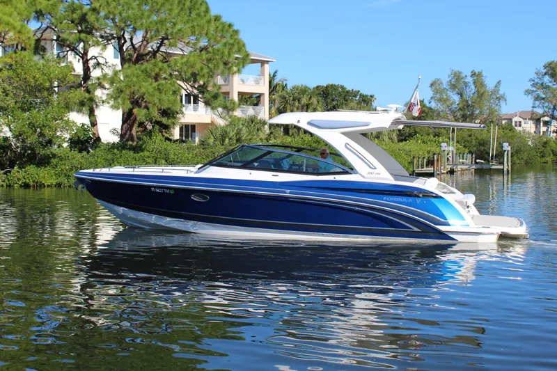 Slide: The Image of 2023 Formula 330 Crossover Bowrider on a serene waterway, surrounded by lush greenery. - 6