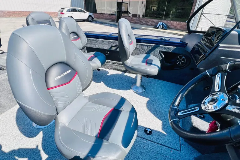Slide: The Image of 2024 Tracker Targa V-18 Combo boat interior with gray and red seating, steering wheel, and dashboard. - 14