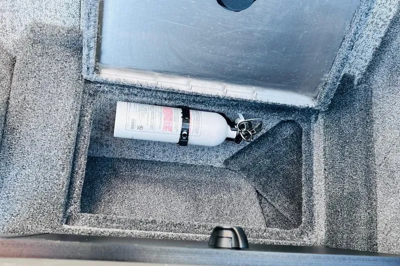 Slide: The Image of 2024 Tracker Targa V-18 Combo storage compartment with fire extinguisher. - 36