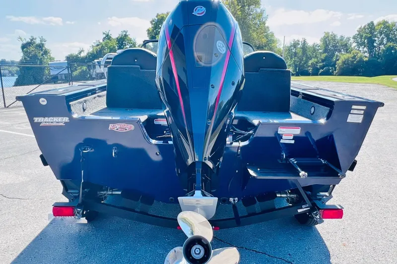 Slide: The Image of 2024 Tracker Targa V-18 Combo boat, rear view with outboard motor, parked outdoors. - 9