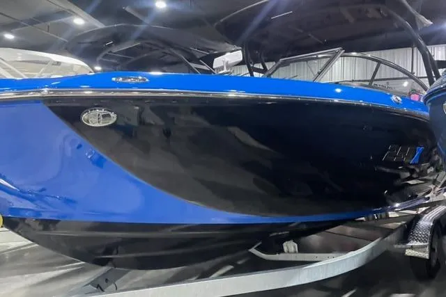 Slide: The Image of 2024 Yamaha Boats 255XD, sleek blue and black design, showcased indoors. - 0
