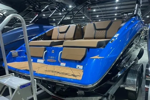 Slide: The Image of 2024 Yamaha Boats 255XD, blue exterior, luxury seating, showcased indoors. - 3
