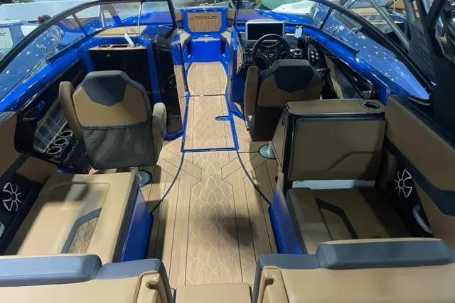 Slide: The Image of 2024 Yamaha Boats 255XD interior with blue and brown seating, modern dashboard, and spacious layout. - 5