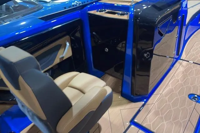 Slide: The Image of 2024 Yamaha Boats 255XD interior with blue accents and tan seating. - 9