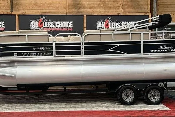 Slide: The Image of 2018 Sun Tracker SportFish 22 XP3 pontoon boat displayed indoors on a trailer. - 8