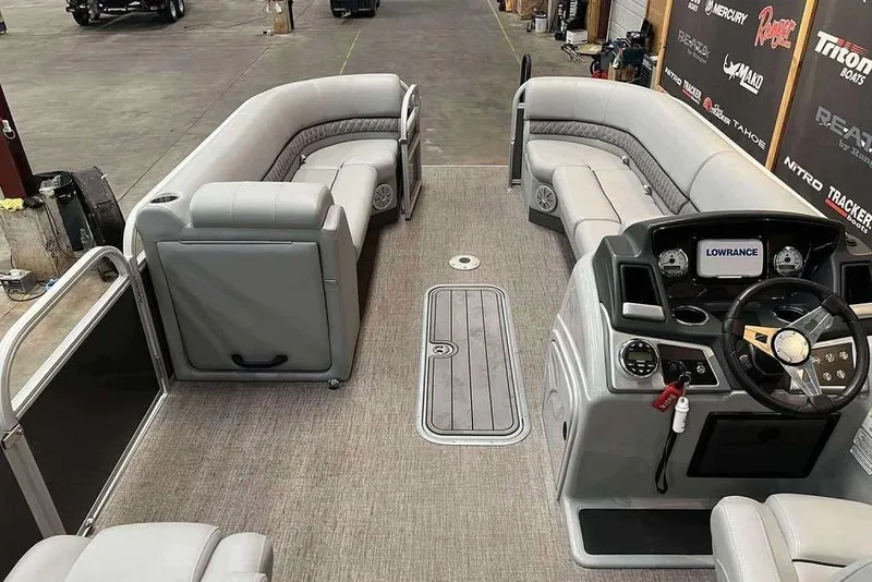 Slide: The Image of Interior of a 2021 Ranger 243C pontoon boat with gray seating and a modern dashboard. - 5